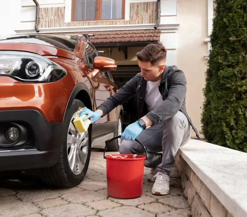 Lavage auto à domicile Dému : professionnel intervenant sur un véhicule